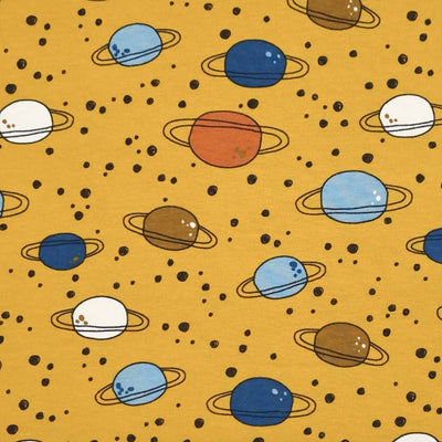 An on trend mustard coloured, 4 way stretch, single cotton jersey fabric featuring planets and rings.