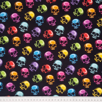 Scattered brightly coloured skulls are digitally printed on a quality black 100% Cotton fabric with a cm ruler at the bottom
