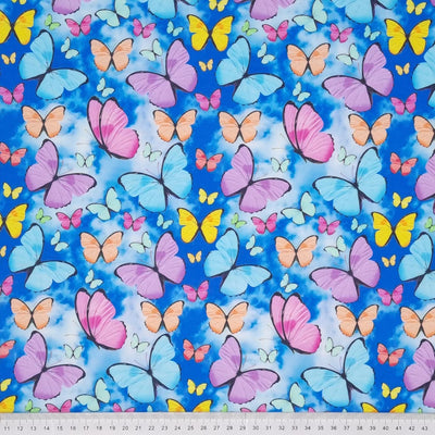 Brightly coloured flying butterflies are digitally printed on a quality clouded sky 100% cotton fabric with a cm ruler at the bottom