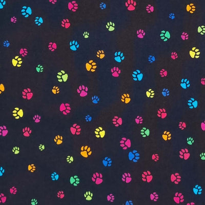 Bright, colourful dog paw prints printed on a black, quality 100% cotton fabric.