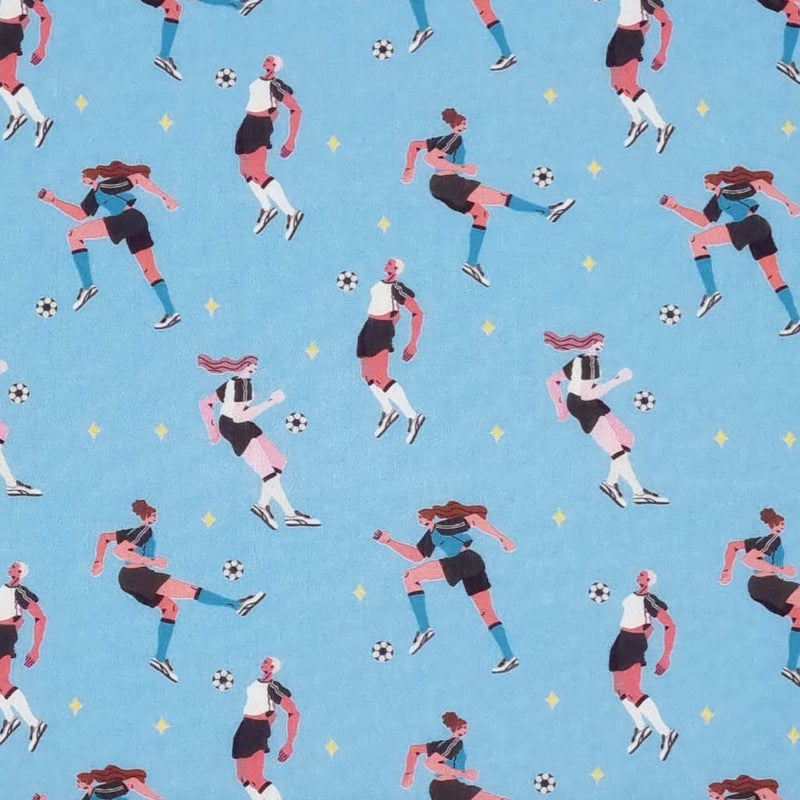 Ladies playing football printed on a sky blue cotton fabric by Little Johnny