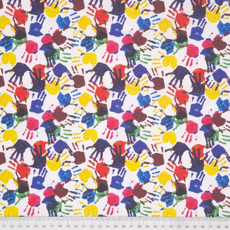 Blue, red, green and yellow painted hand prints are digitally printed on a quality white 100% cotton fabric with a cm ruler at the bottom