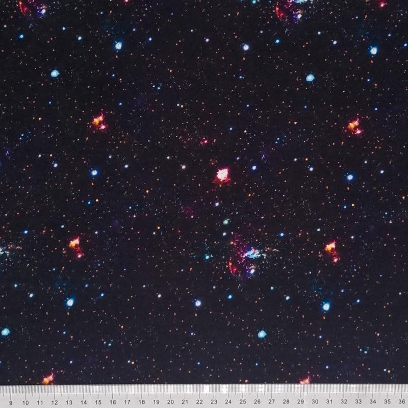 A galaxy scene printed on a black cotton fabric with a cm ruler
