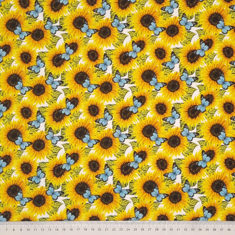 Beautiful bright sunflowers with vibrant blue butterflies are digitally printed on a quality white 100% cotton fabric with a cm ruler at the bottom