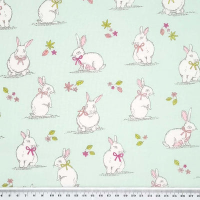 An endearing woodlland scene featuring bunny rabbits, all printed on a duck egg, 100% cotton fabric with a cm ruler