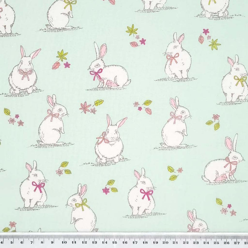 An endearing woodlland scene featuring bunny rabbits, all printed on a duck egg, 100% cotton fabric with a cm ruler