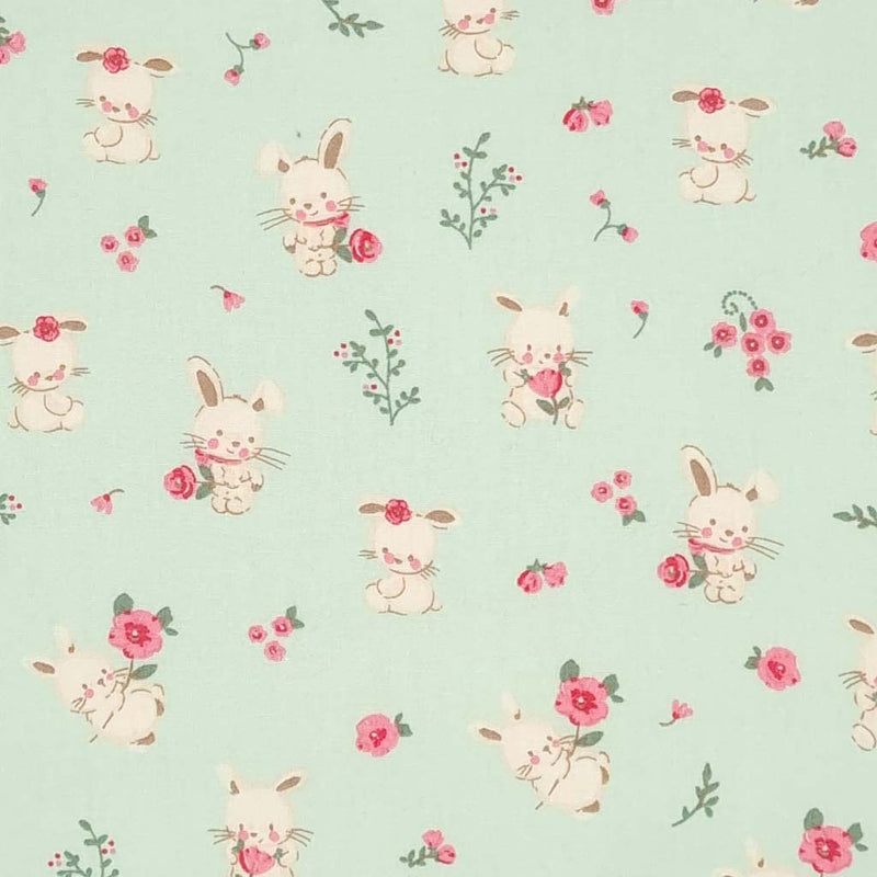 Cute bunnies and pink flowers printed on a mint cotton poplin fabric