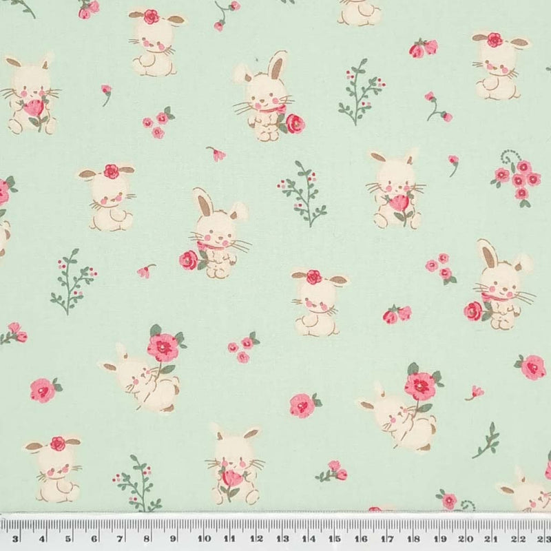 Cute bunnies and pink flowers printed on a mint cotton poplin fabric with a cm ruler
