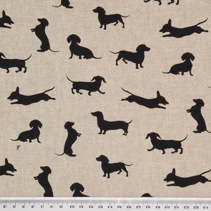 Black silhouettes of dachshund dogs are printed on a craft canvas fabric with a cm ruler