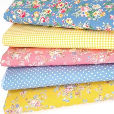 A fat quarter bundle of copen blue, pink and yellow florals, spots and checks