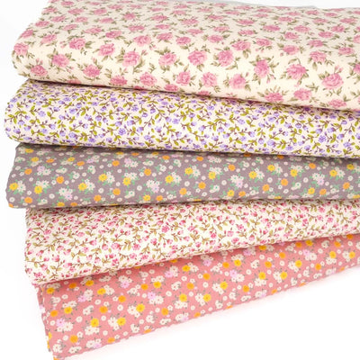 Five fat quarters with ditsy floral designs on cotton poplin fabric