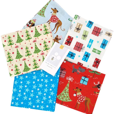 A christmas fat quarter bundle of 5 cotton fabrics with dogs, stars and xmas trees