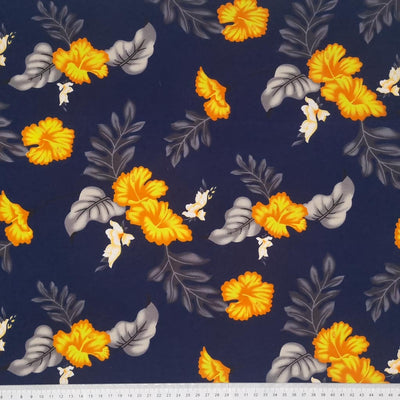 Vibrant orange flowers are printed on a navy coloured cotton poplin. with a cm ruler at the bottom