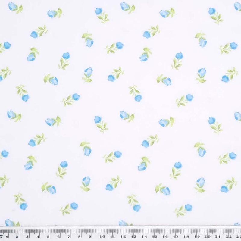 Blue baby roses are printed on a white polycotton fabric with a cm ruler