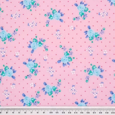 A beautiful mint, vintage blooming rose polycotton fabric on a pink background with a cm ruler
