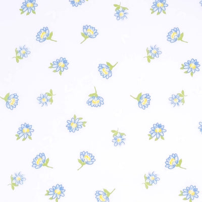 Delicate blue daisies are printed on a white polycotton fabric