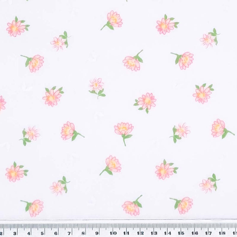 Pink delicate daisies printed on a white polycotton fabric with a cm ruler