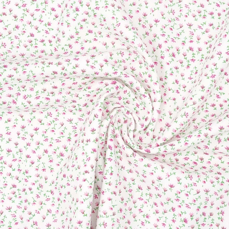 A delicate ditsy pink floral print on a quality white polycotton fabric