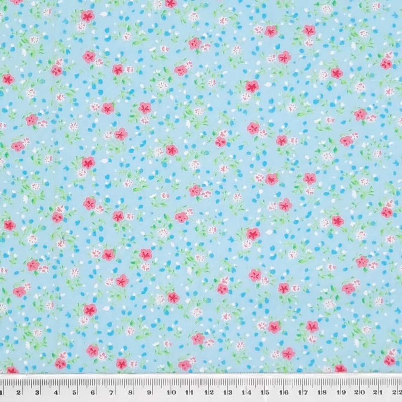 A delicate ditsy floral polycotton in turquoise. with a cm ruler