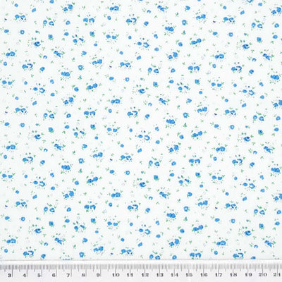 A ditsy blue rose bud fabric print on polycotton with a cm ruler