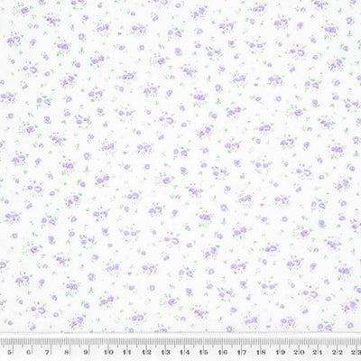 A ditsy lilac rose bud fabric print on polycotton with a cm ruler
