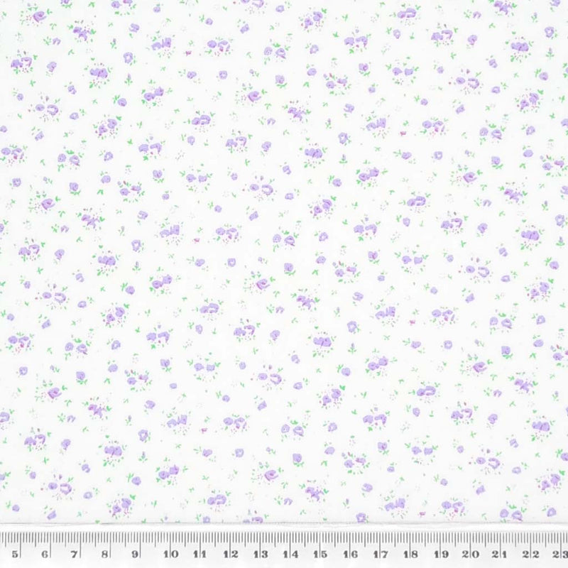 A ditsy lilac rose bud fabric print on polycotton with a cm ruler