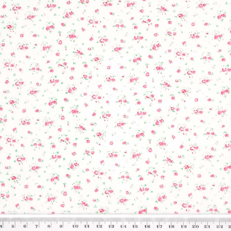 A ditsy pink rose bud fabric print on polycotton with a cm ruler