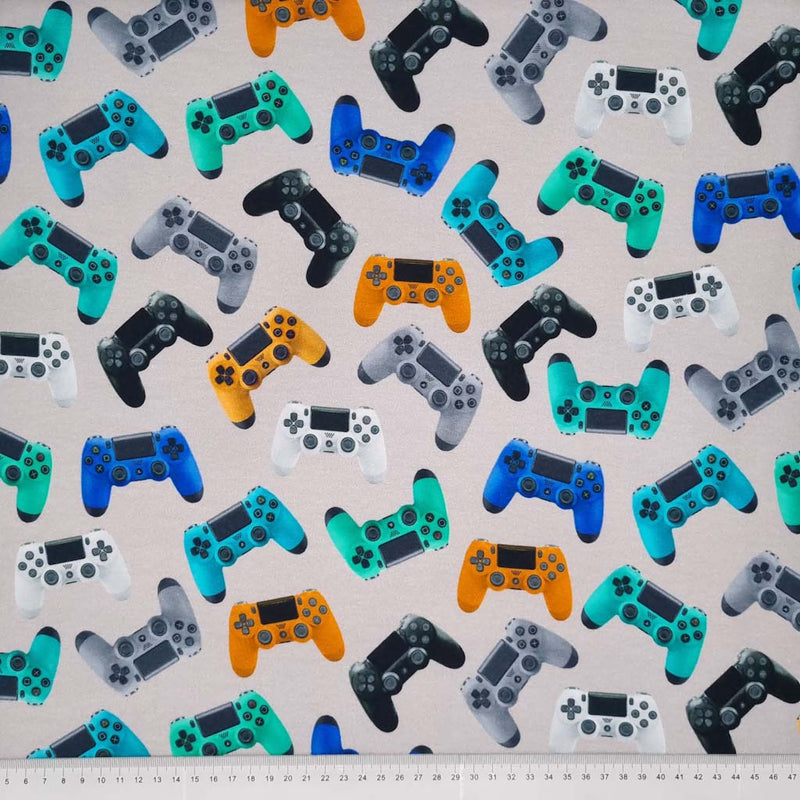 Multi coloured game controllers printed on a light grey soft sweat jersey fabric with a cm ruler at the bottom