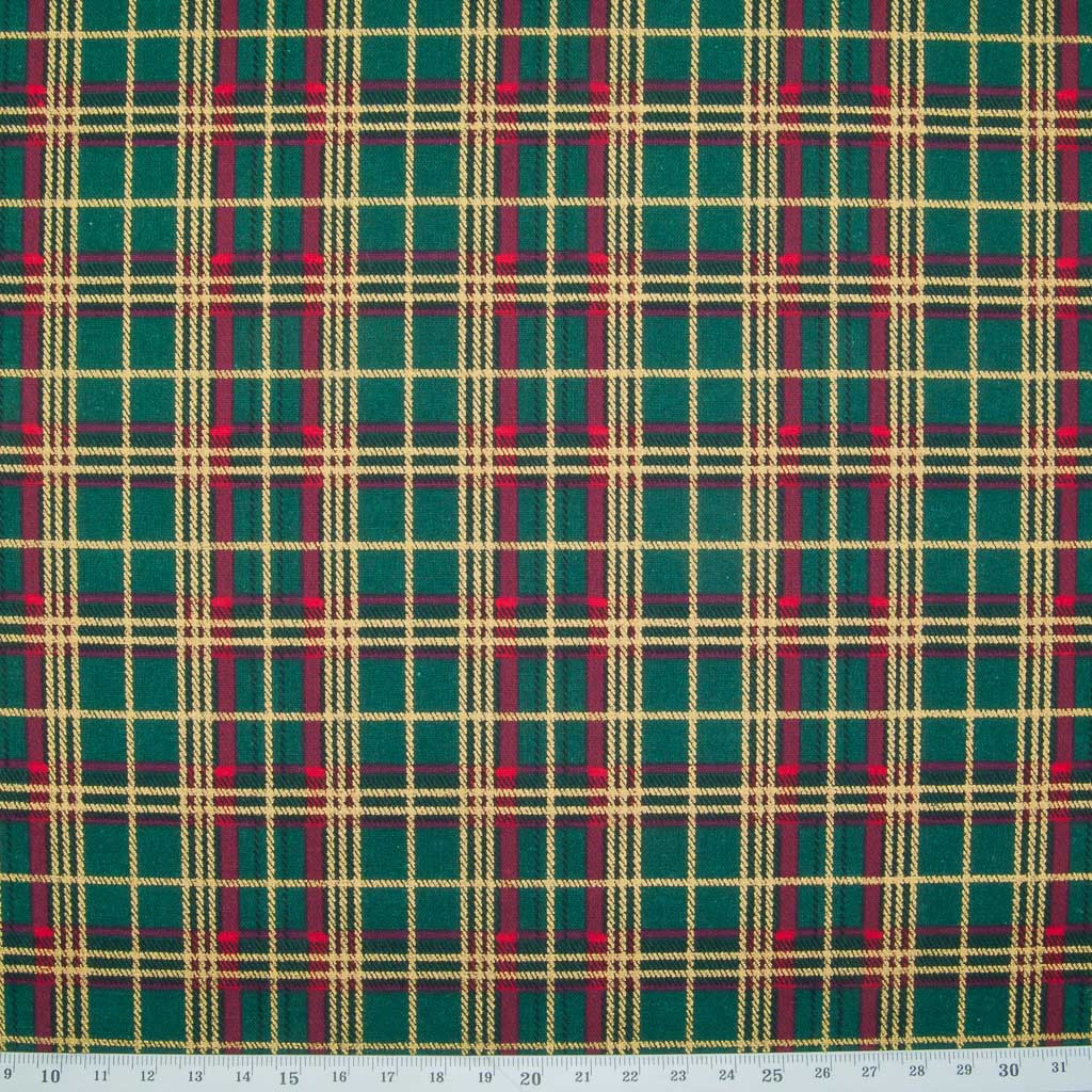 A medium sized gold lacquered and red tartan check on a green cotton fabric with a ruler at the bottom
