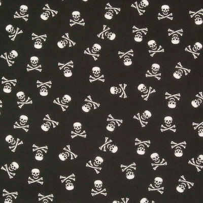Small white skull and crossbones are printed on a black halloween polycotton fabric