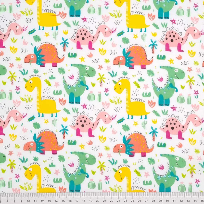 Friendly colourful dinosaurs are printed on a white polycotton fabric with a cm ruler at the bottom