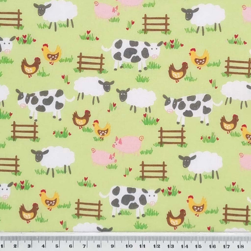 Chicken, sheep, cows and pigs are printed on a green polycotton fabric with a cm ruler