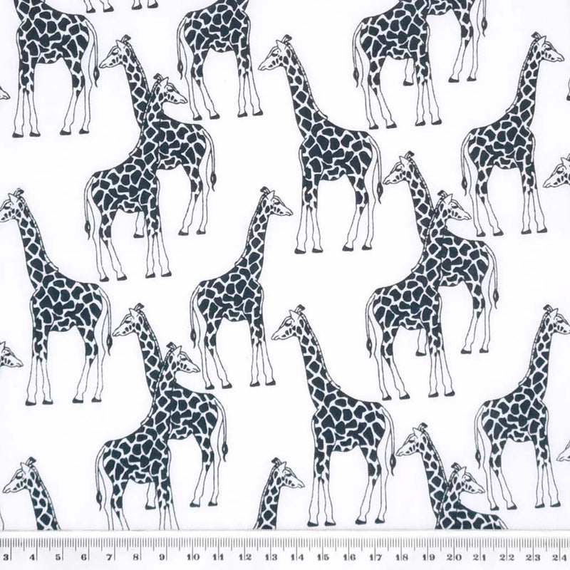 Black and white giraffes are printed on a white polycotton fabric with a cm ruler