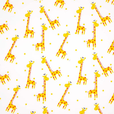 A happy scattered giraffe print with spots printed on a white polycotton fabric. 