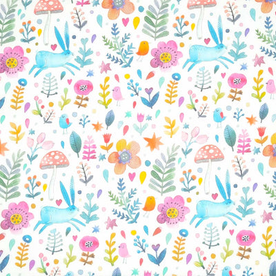A blue rabbit, red toadstool, orange flowers and pink birds printed on a fat quarter of cotton fabric