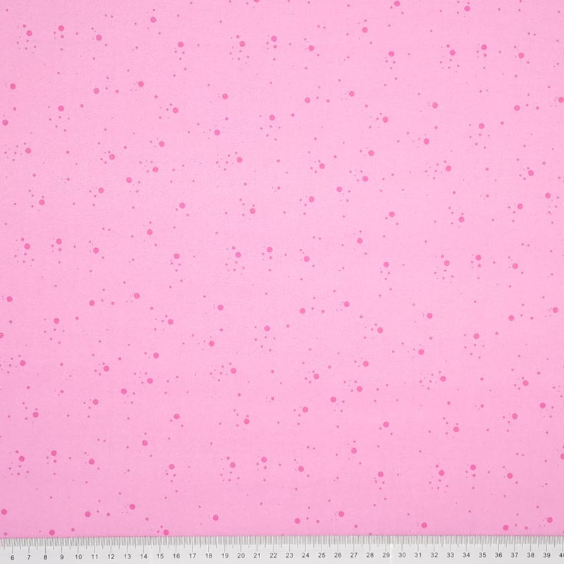 Dark pink speckled spots printed on a candy pink, 100% cotton fabric with a cm ruler at the bottom