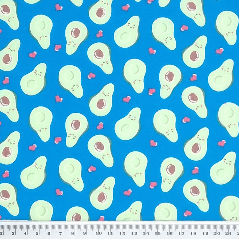 Smiling avocados are printed on a quality blue polycotton fabric with a cm ruler