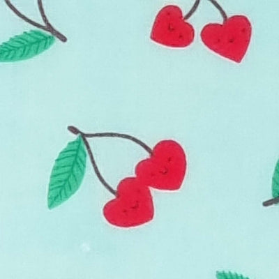 Smiling red heart shaped cherries printed on a blue polycotton fabric
