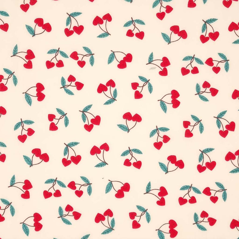 Red heart shaped cherries printed on a cream polycotton fabric