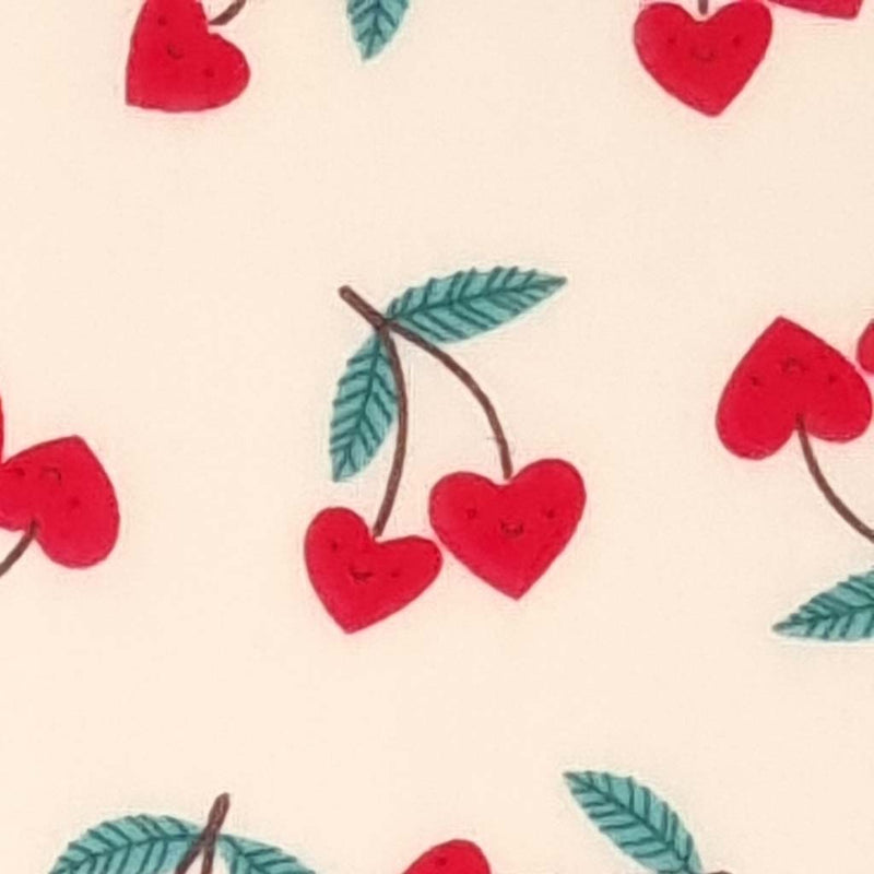 Smiling red heart shaped cherries printed on a cream polycotton fabric