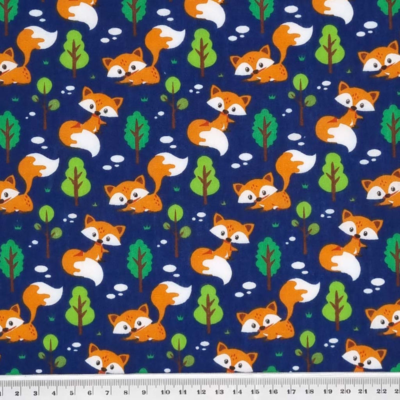 Curious foxes are printed on a navy polycotton fabric with a cm ruler