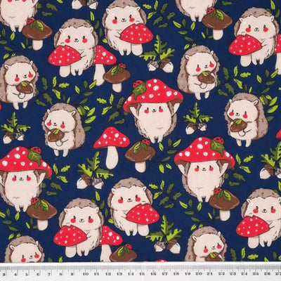 Cute hedgehogs and toadstools with ladybirds are printed on a navy polycotton fabric with a cm ruler