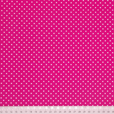 A mini white spot design printed on a cerise Rose and Hubble cotton poplin fabric with a cm ruler at the bottom
