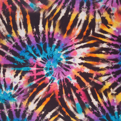 A brightly coloured tie dye viscose fabric printed with a spiralling catherine wheel design