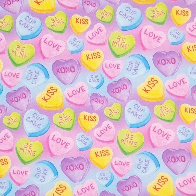 Colourful love heart sweeties printed on a lilac and sky blue cotton fabric
