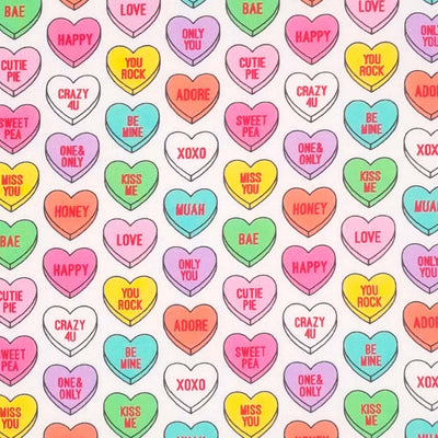 Colourful candy love hearts printed on a white cotton fabric
