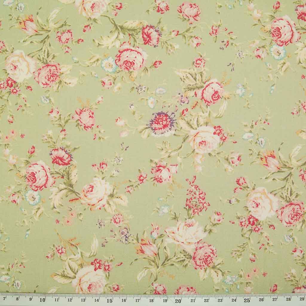A floral pattern of pink and pale roses on a green fat quarter of Rose & Hubble cotton poplin fabric with a cm ruler at the bottom