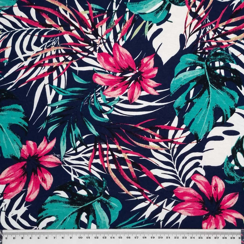 A tropical floral print in green and fuchsia printed on a viscose jersey fabric with a cm ruler